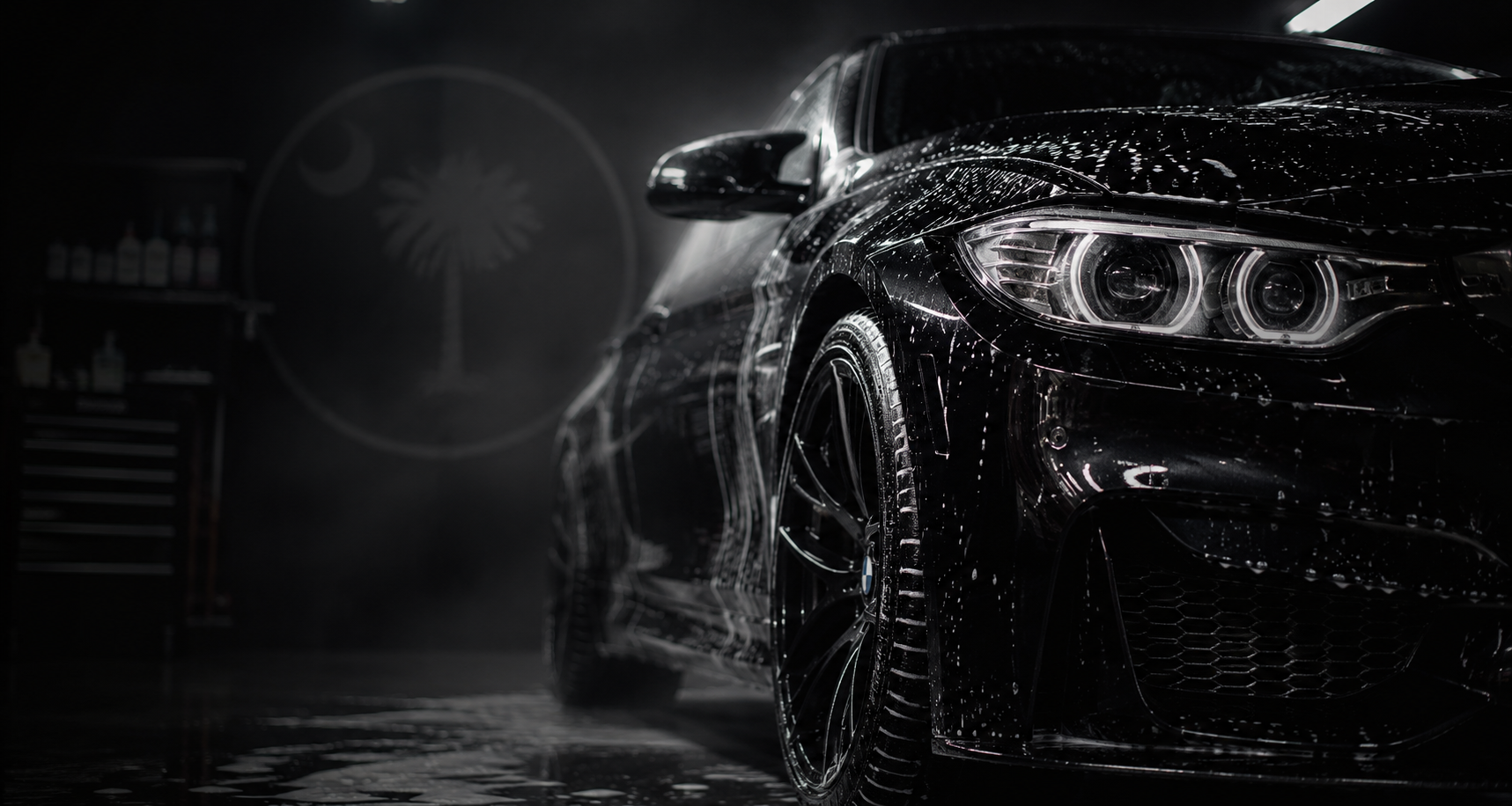 Black BMW with water beading in a dark detailing studio — supplied concept image