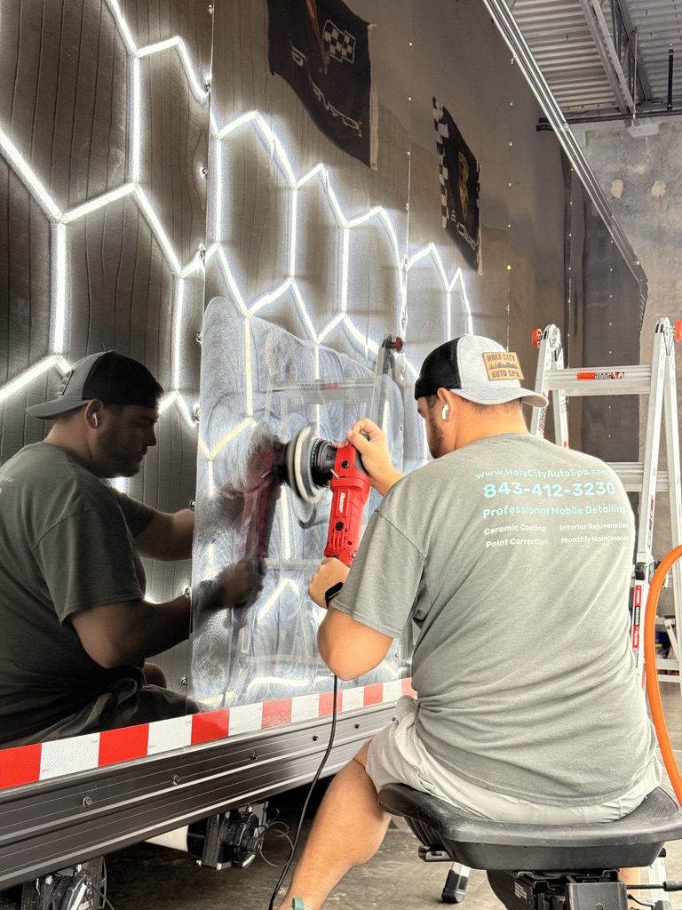 Holy City Auto Spa detailer machine-polishing a reflective trailer panel